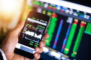 a person holding a smartphone with stock market data on it trading wallpaper