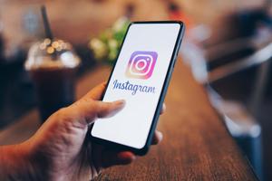 a person holding an instagram phone with the logo on it instagram wallpaper