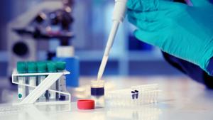 a person is working in a laboratory with a test tube Wallpaper