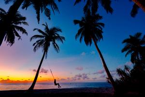 a person swinging on a swing beach wallpaper