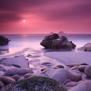 a pink sunset over rocks and water aesthetic ipad wallpaper