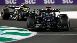 a race car is driving down a track f1 wallpaper