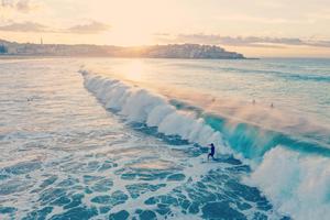 a surfer is riding a wave at sunset beach wallpaper
