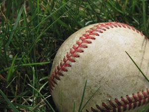 A used, dirty baseball lays on the grass baseball wallpaper
