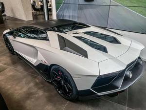 a white and black lamborghini huracan is parked in a showroom Wallpaper
