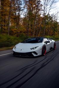 a white sports car driving down a road lamborghini wallpaper