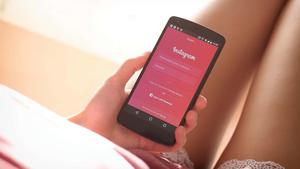 a woman holding a smartphone with instagram on it instagram wallpaper