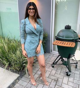 a woman in a blue dress standing next to a green grill mia khalifa wallpaper