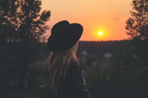 a woman in a hat looking at the sunset instagram profile wallpaper