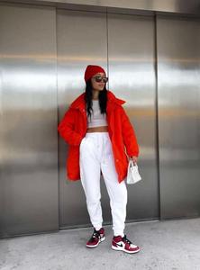 a woman in a red puffer jacket standing in front of an elevator baddie wallpaper
