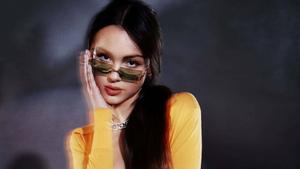 a woman in a yellow shirt with sunglasses olivia rodrigo wallpaper