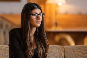 a woman in glasses sitting on a couch mia khalifa wallpaper
