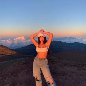 a woman in ripped jeans standing on top of a mountain aesthetic girl wallpaper