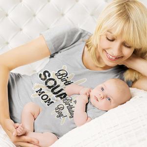 a woman laying on a bed with a baby matching wallpaper