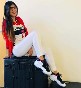 a woman sitting on a suitcase with sneakers mia khalifa wallpaper