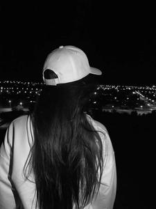 a woman wearing a baseball cap looking out at the night sky instagram profile wallpaper