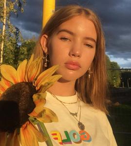 A young girl stares off into the horizon while admiring a beautiful sunset aesthetic girl wallpaper