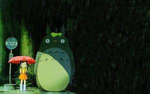 An adorable Totoro embracing a stroll in the lush nature totoro wallpaper