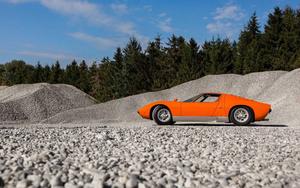 An exquisite orange Lamborghini Miura on a gravel road. lamborghini wallpaper