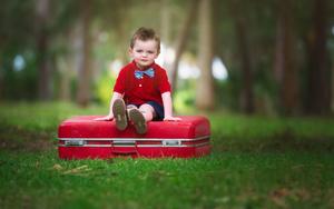 Baby Boy Seated On Red Suitcase baby boy wallpaper