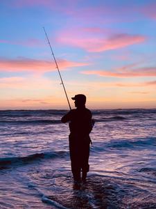 Enjoying a day of fishing on the beach fishing wallpaper