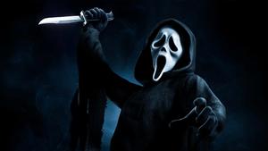 Ghostface stands menacingly atop a mountain of horror movies ghostface wallpaper