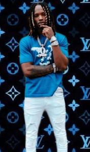 King Von poses confidently in a stylish outfit. king von wallpaper