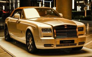 Luxurious Rolls-Royce on an Elegant Urban Road Wallpaper