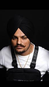 Sidhu Moose Wala posing with his Moosetape album poster.  Wallpaper