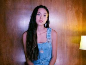 Singer-songwriter Olivia Rodrigo enjoying an electric guitar performance olivia rodrigo wallpaper