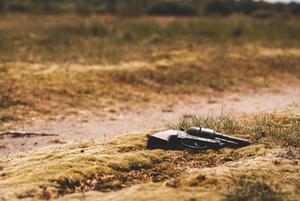 Solitary Revolver Resting on Rough Terrain gun wallpaper