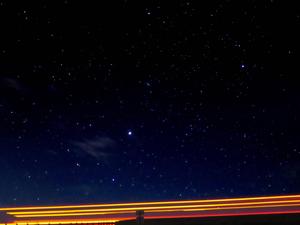 Streaks Of Light Under A Starry Night sky wallpaper