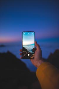 Taking Seaside Photo Using Phone phone wallpaper