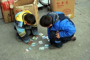 two boys playing cards on the street trading wallpaper