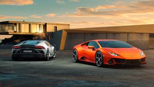 two sports cars parked in front of a building lamborghini wallpaper
