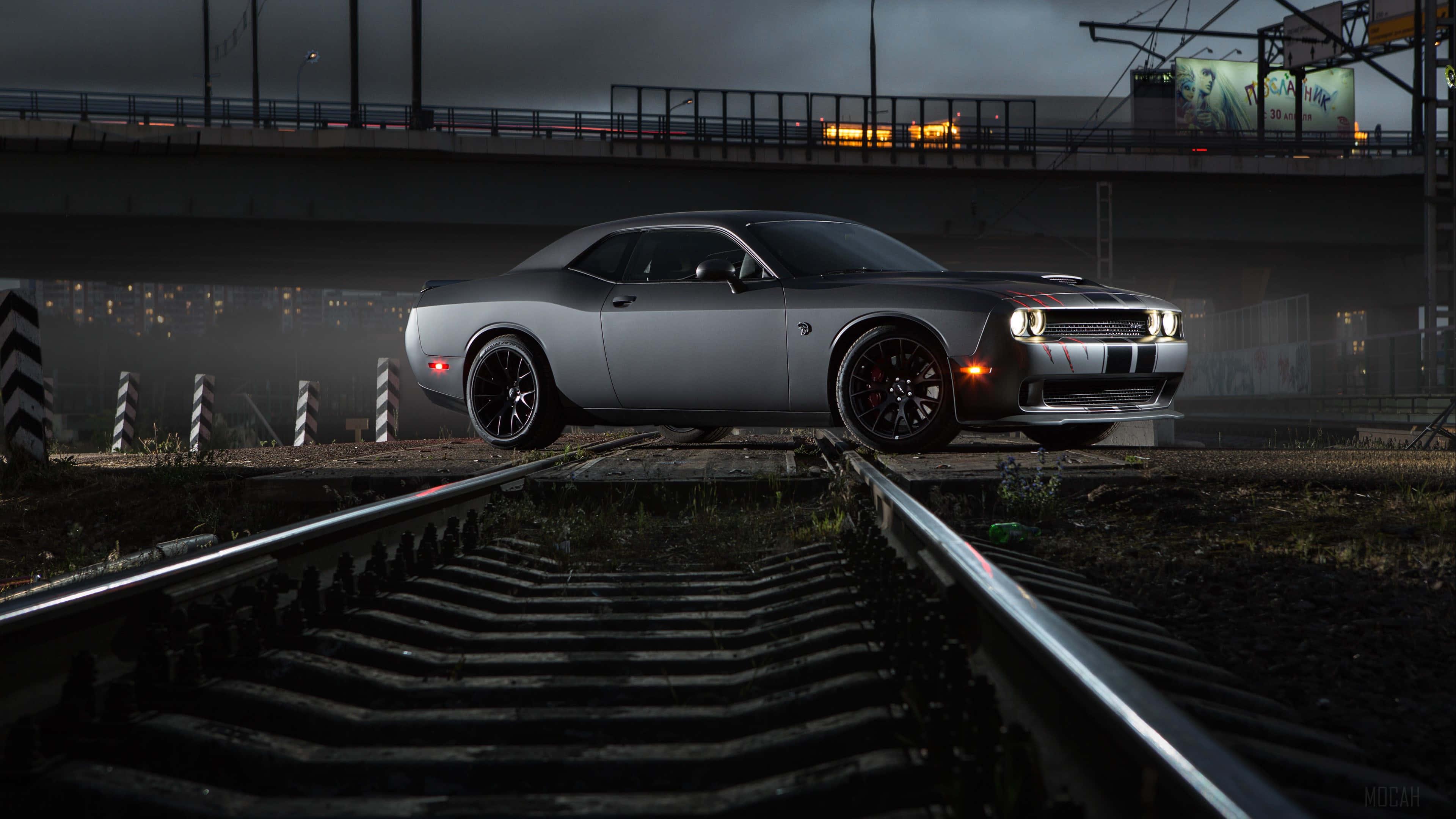 a black car is driving down the tracks at night — 3840x2160 wallpaper