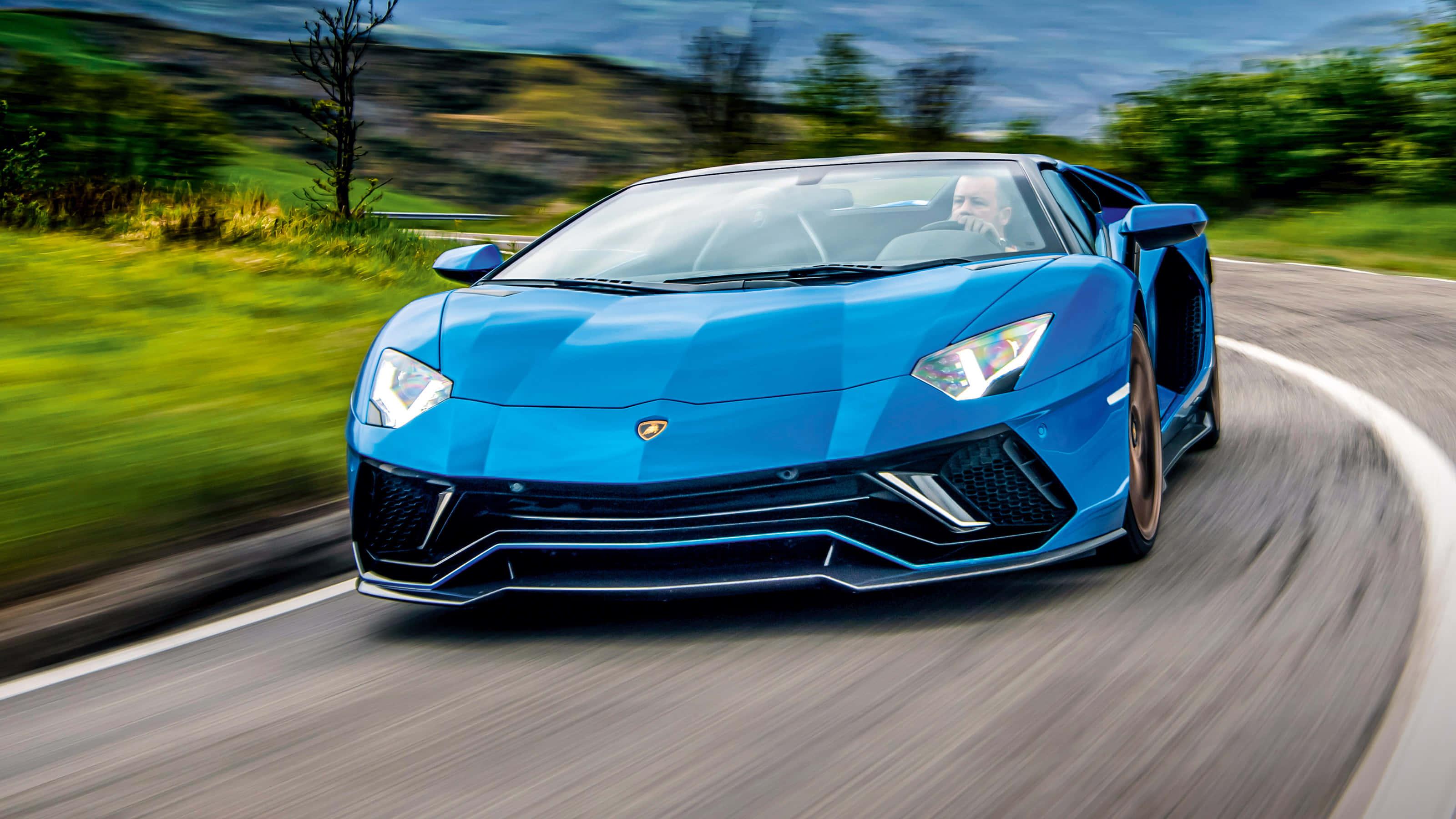 a blue sports car driving down a road — 3200x1800 wallpaper