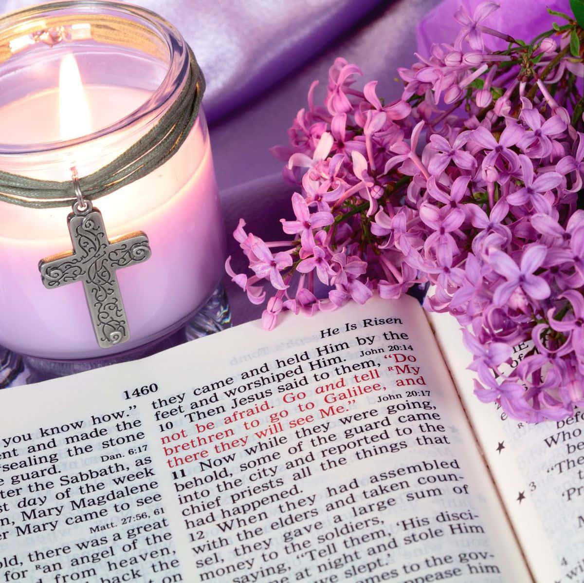 a candle and a bible with lilac flowers — 1200x1197 wallpaper