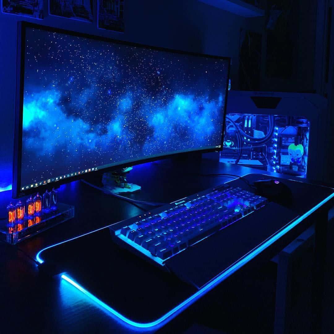 a computer desk with a blue light on it — 1080x1080 wallpaper