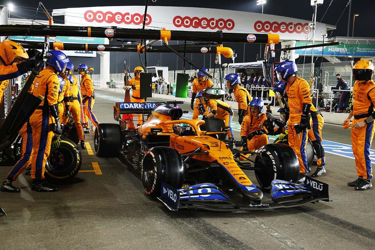 a group of people working on a racing car — 1200x800 wallpaper