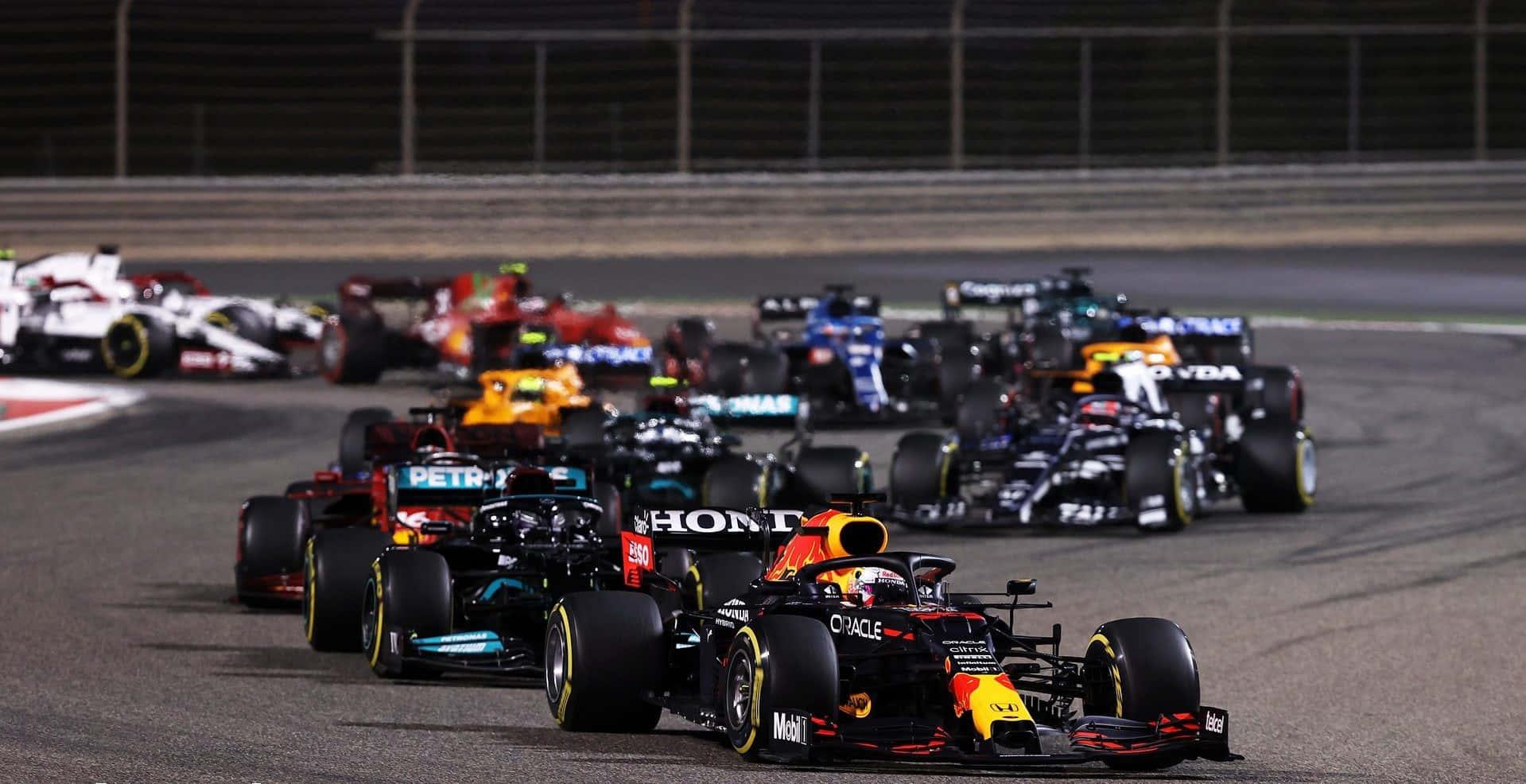 a group of racing cars are racing down a track — 1919x986 wallpaper