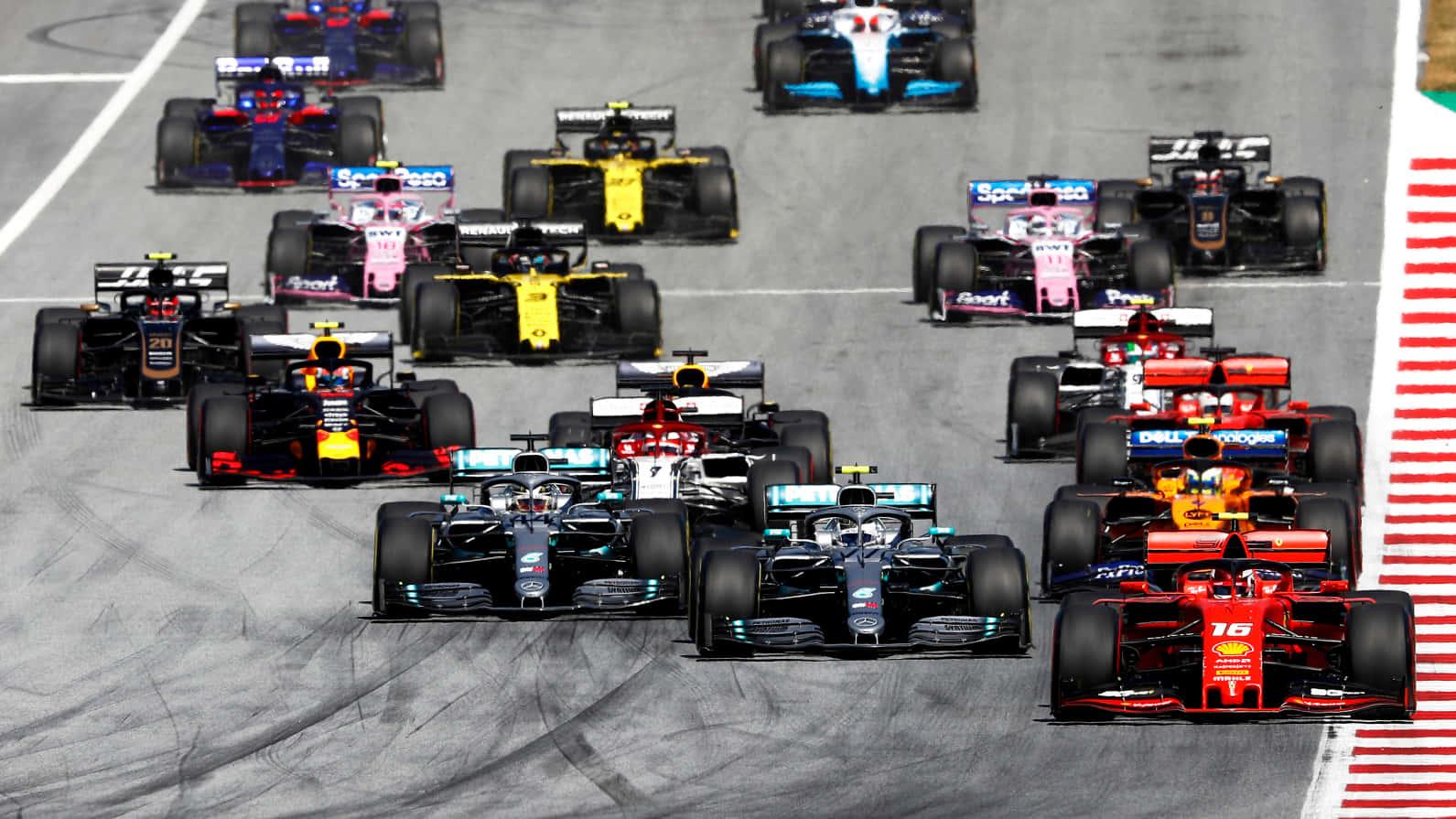 a group of racing cars are racing down a track — 1591x895 wallpaper