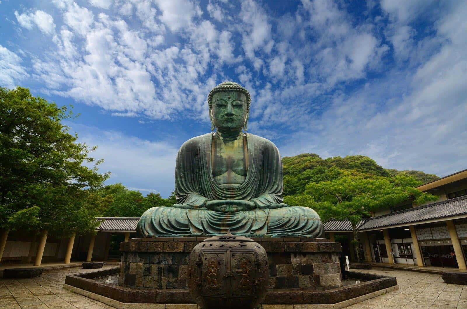 a large statue of a buddha in a courtyard — 1600x1059 wallpaper