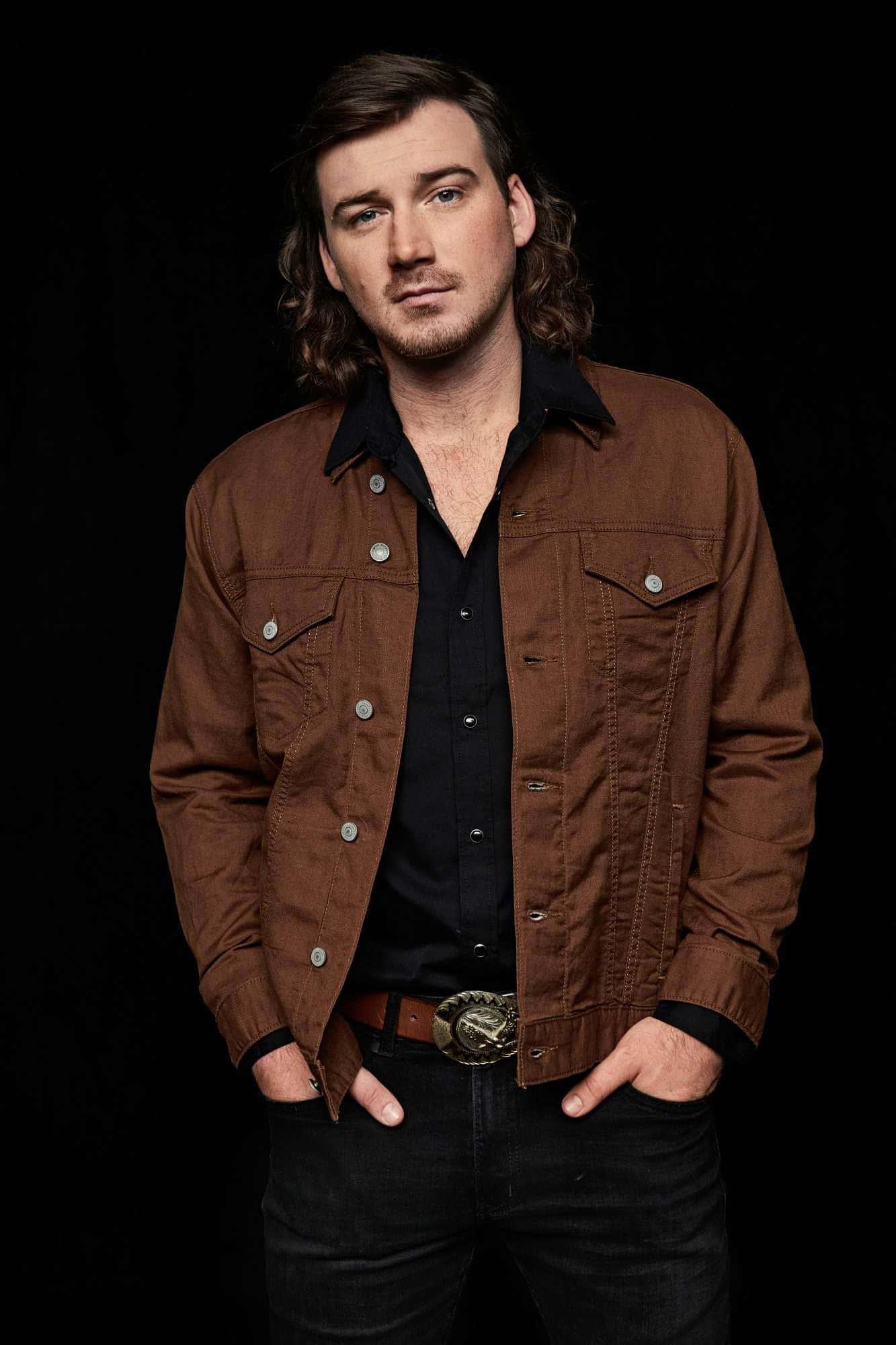a man in a brown jacket posing for a photo — 1333x2000 wallpaper