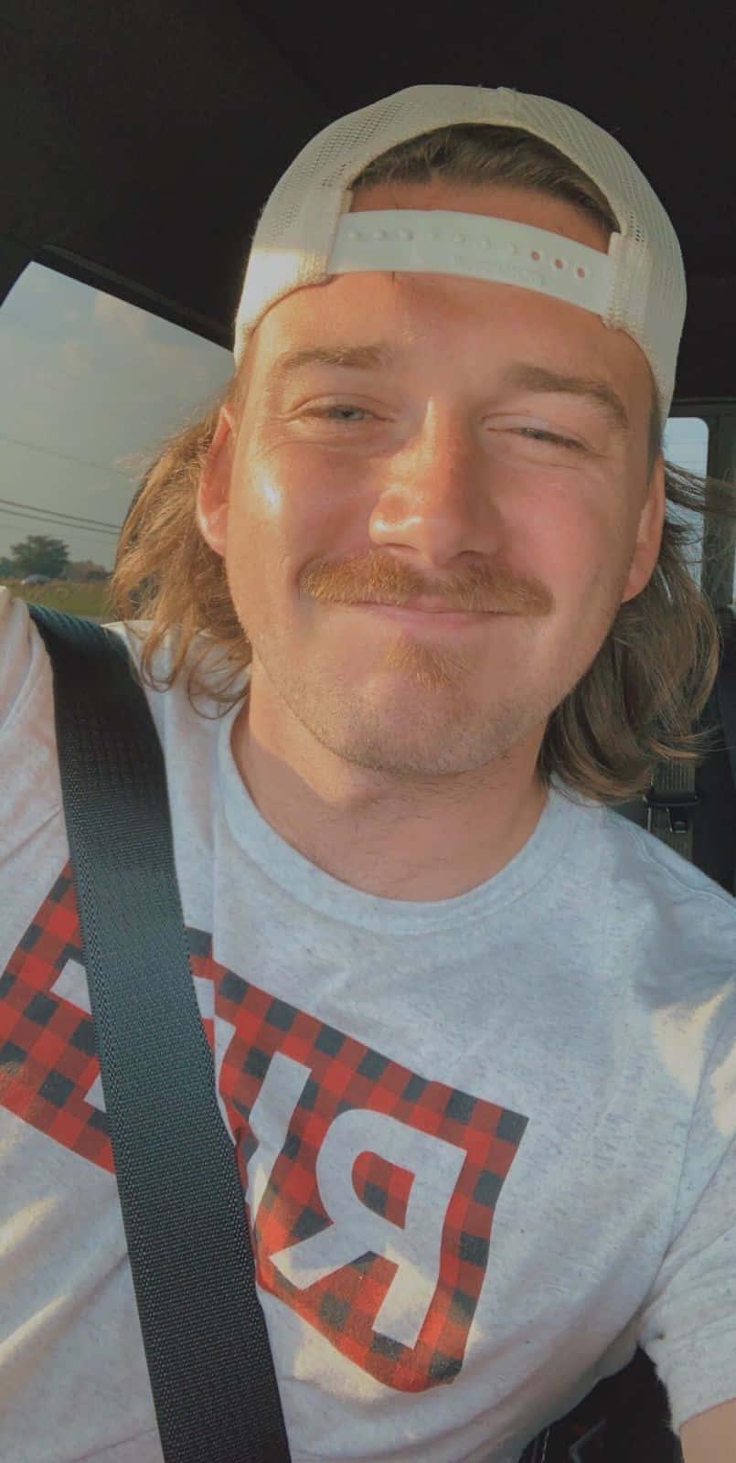 a man in a plaid shirt is taking a selfie in his car — 805x1600 wallpaper