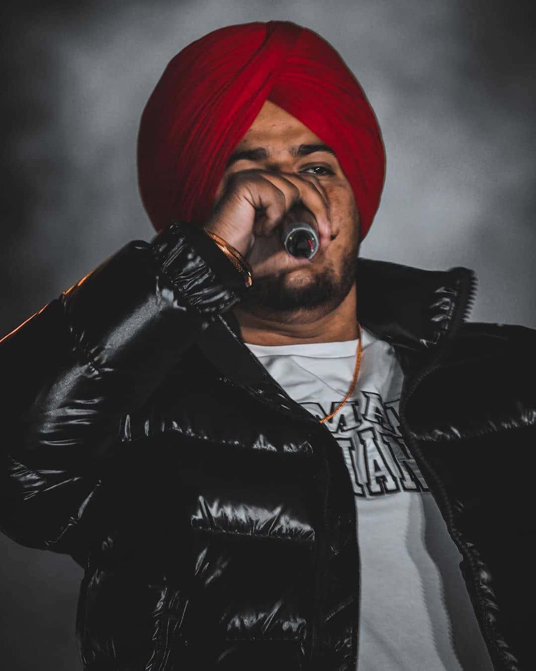 a man in a red turban singing into a microphone