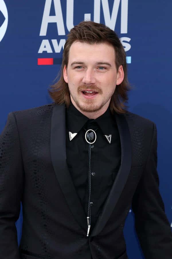 a man in a suit and tie standing on the red carpet — 600x900 wallpaper