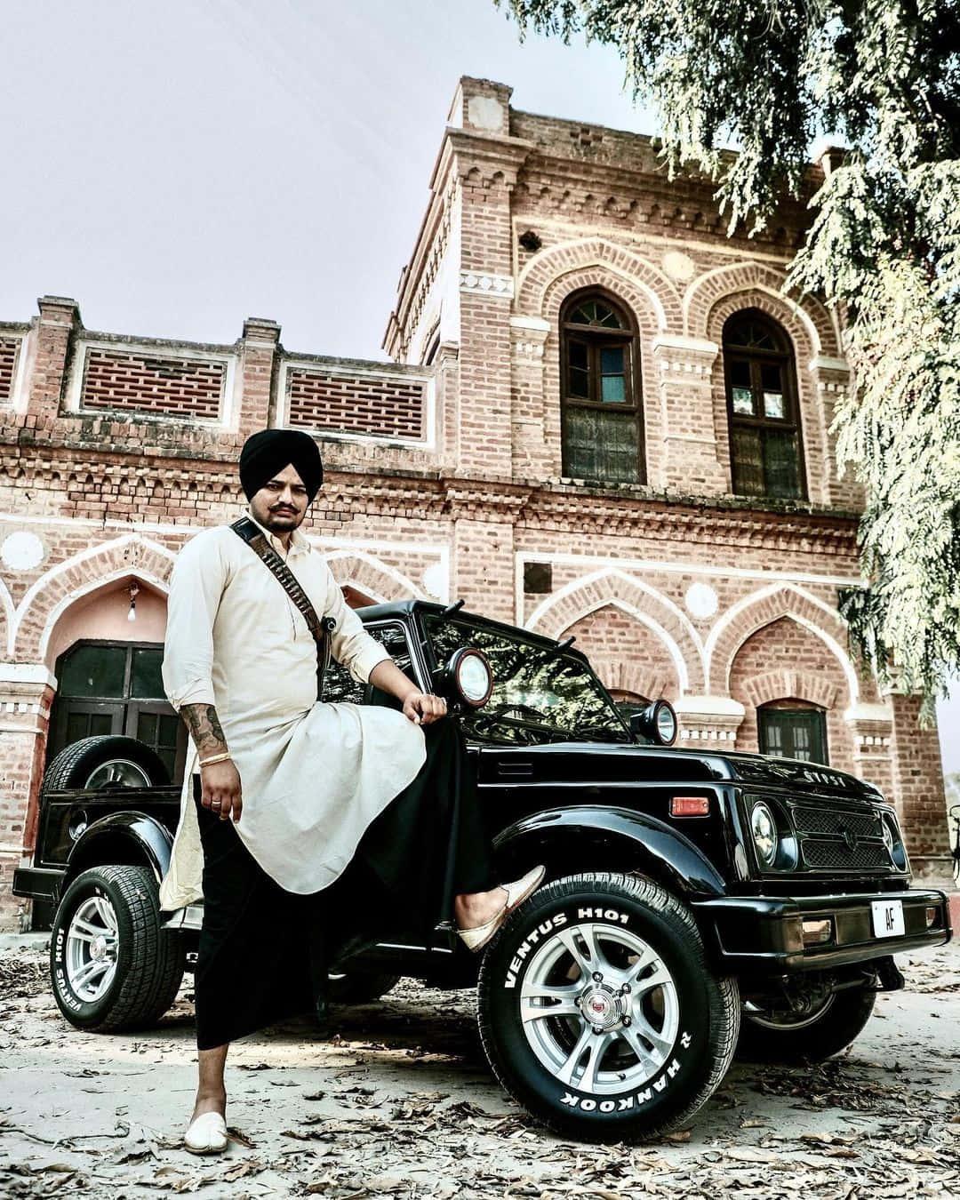 Ein mann mit turban steht neben einem jeep