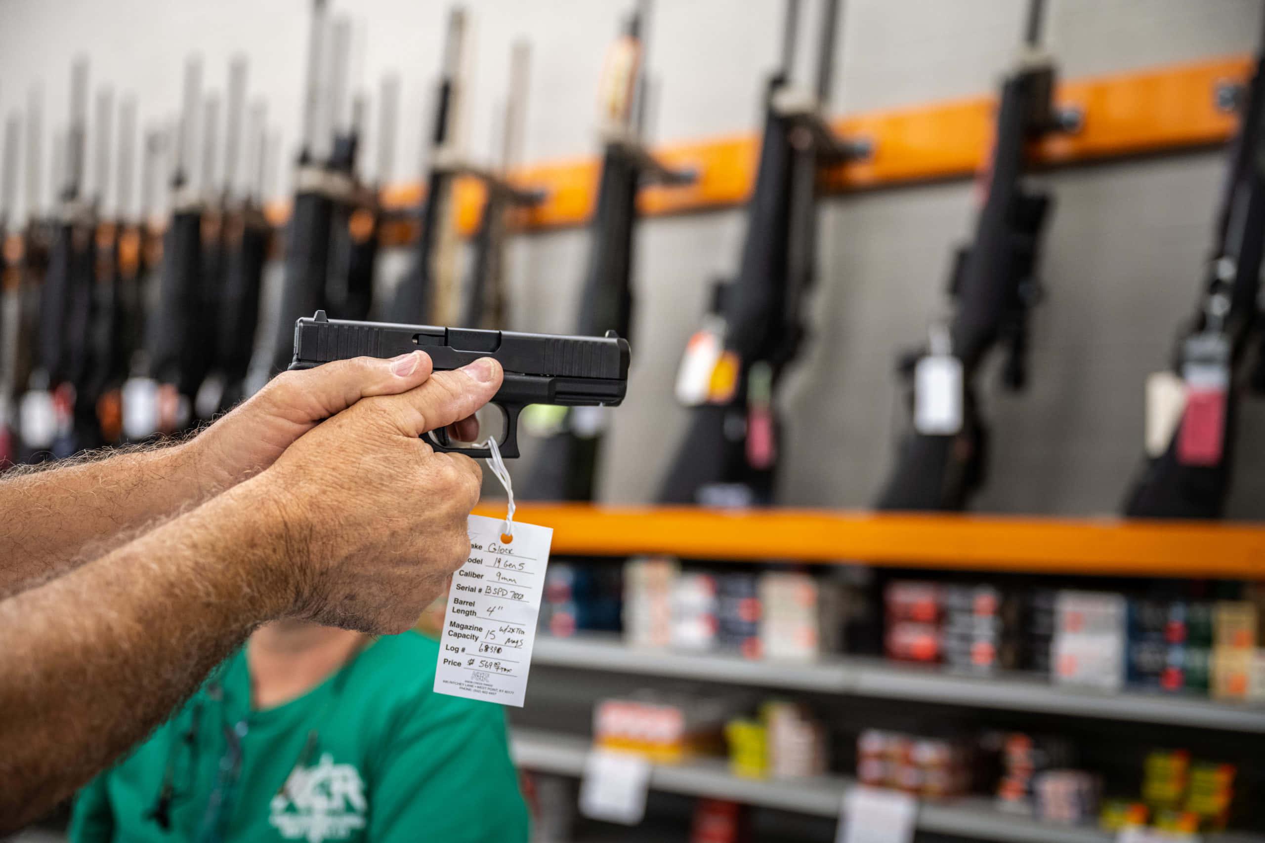 a man is holding a gun in a store — 2560x1707 wallpaper