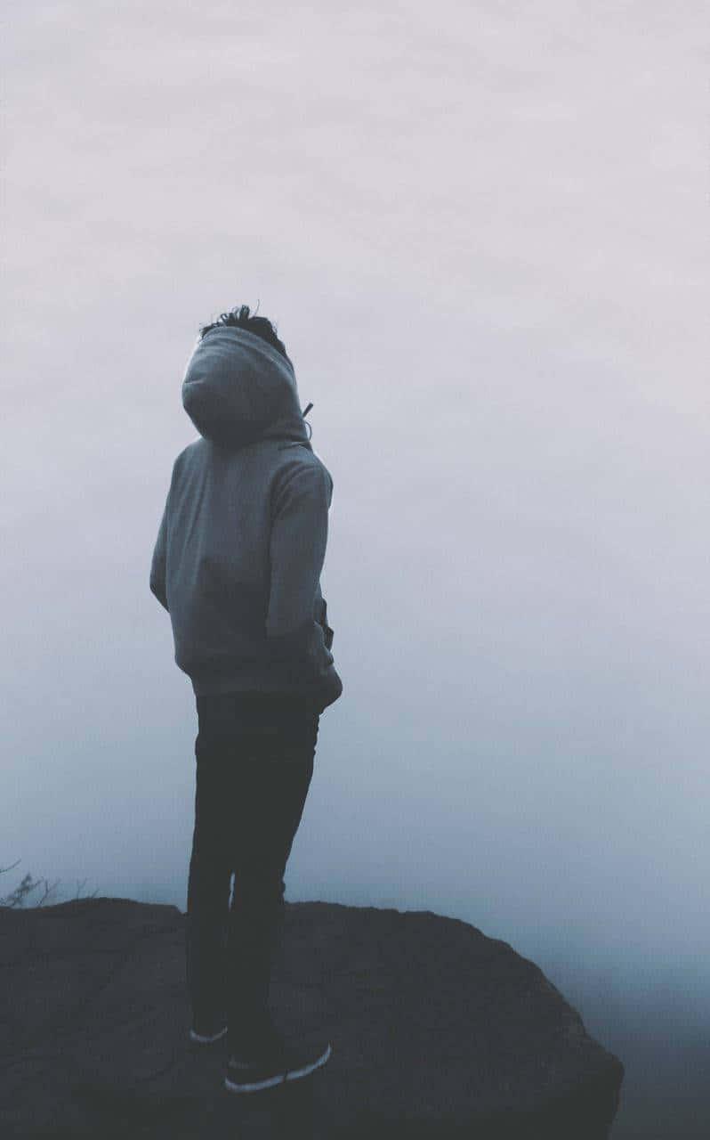 a man standing on a cliff looking at the fog — 798x1280 wallpaper